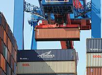 011_97_2433 Der Container wird an dem Laufwagen der Containerbrücke über die Schiffsladung gehoben und zum Weitertransport abgesetzt. 