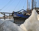 011_26074 Eisschollen am Ufer der Elbe vom Museumshafen Hamburg Oevelgoenne - die Wintersonne scheint auf das Eis. Ein historisches Segelboot liegt an seinem Liegeplatz im Hafen und überwintert dort. Das Wasser der Elbe ist gefroren. ©www.hamburg-fotograf.com