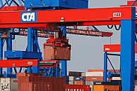 011_15652 der Container hängt an einem fahrbaren Kran und wird auf dem Lagergelände gestapelt. Im Hintergrund die Containerbrücken mit dem Schriftzug CONTAINER TERMINAL ALTENWERDER CTA.