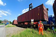 011_15723 Beladung eines Güterzugs mit Containern im Hafengebiet Hamburgs - ein Portalhubwagen holt den Container vom Lager und senkt ihn vorsichtig auf den Güterwaggon. Nachdem der Container seine Platz gefunden hat, fährt die Lokomotive den Güterzug einen Waggon vor, damit der nächste leere Wagen beladen werden kann. Hafenarbeiter überwachen den Vorgang. 