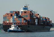 011_26036  Schlepper bringen einen Containerriesen aus dem Hamburger Hafen in die Fahrtrinne der Elbe; das Containerschiff ist hoch mit den grossen Metallboxen beladen.   ©www.christoph-bellin.de