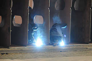 5109 Werftarbeiter / Schweisser schweissen Stahlspanten für einen Schiffsrumpf zusammen.