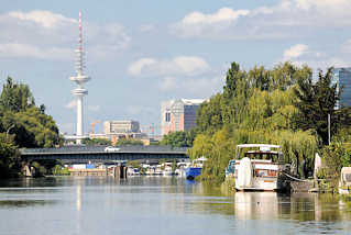 8316 Sportboote liegen am Ufer der Schrebergärten des Bullenhuser Kanals in Hamburg Rothenburgsort - im Hintergrund die Brücke vom Ausschläger Billdeich und der Hamburger Fernsehturm.