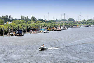 9259 Spreehafen in Hamburg Wilhelmsburg / Kleiner Grasbrook - Wohnboote liegen am Ufer des Hafens - eins Sportboot / Schlauchboot mit Aussenbordmotor fährt Richtung Veddeler Kreuz, Müggenburger Zollhafen.