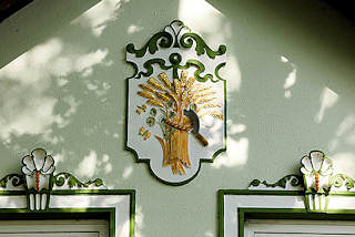 8189 Stuckdekor an der Fassade eines Hauses - vergoldete Ährengarbe und Sichel - Fotos aus Hamburg GUT MOOR.