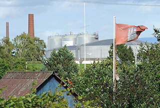 8003 Hamburg Flagge im Kleingartengelände - Öltanks und Schornsteine einer Erdöl-Raffinerie im Harburger Seehafen.