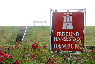 0677 rotes Schild mit Wappen der Freien und Hansestadt Hamburg - Treppe auf den Deich - Sitzbank auf dem Deich von Neuwerk.