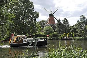 Reitbrooker Mühle am Ufer der Dove-Elbe - Windmühle mit Flügeln in Hamburg - Schilf am Flussufer - Motoboot in Fahrt. Bilder aus den Stadtteilen und Bezirken der Hansestadt Hamburg - Fotos von Hamburg REITBROOK, Bezirk Hamburg BERGEDORF. Seit 1768 gehört Reitbrook zu Hamburg - jetzt leben auf 6,9 km² ca. 500 Einwohner.