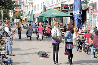 8704 Hamburg im Sommer - Leben im Sternschanzenviertel - Tische auf der Strasse in der Sonne.