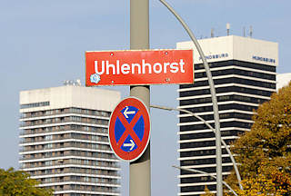 0070 Stadtteilschild UHLENHORST an einem Laternenpfahl - Stadtteilgrenze; im Hintergrund Hochhäuser am Mundsburg.