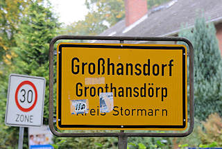 5594 Ortsschild Großhansdorf - Plattdeutsch Groothansdörp, Kreis Stormarn; gelber Grund mit schwarzer Schrift.