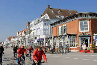 0468 FahrradfahrerInnen auf der Promenade von Lübeck-Travemünde - historische Bäderarchitektur an der Ostsee.