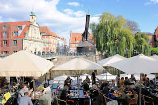 1937 Restaurant unter Sonnenschirmen am Hafen von Lüneburg - im Hintergrund die Barockfassade vom Alten Kaufhaus und der Alte Kran am Hafenkai.
