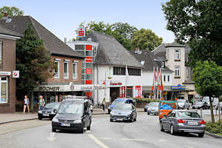 2611 Einkaufsstrasse in Reinbek, Bahnhofsstrasse; Einzelhäuser mit Geschäften - fahrende PKW / Autos.