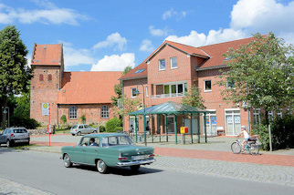 7329 Am Markt von Sülfeld - historische Sülfelder Kirche - schlichter Neubau, Bushaltestelle mit Metall-Wartehäuschen.