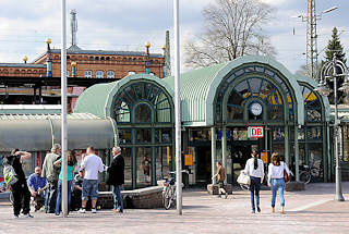 3471 Moderner Eingang vom Bahnhof Uelzen - Passanten und Fahrgäste; im Hintergrund das historische Bahnhofsgebäude, das 2000 nach Plänen des österreichischen Künstlers Friedensreich Hundertwasser umgebaut wurde.